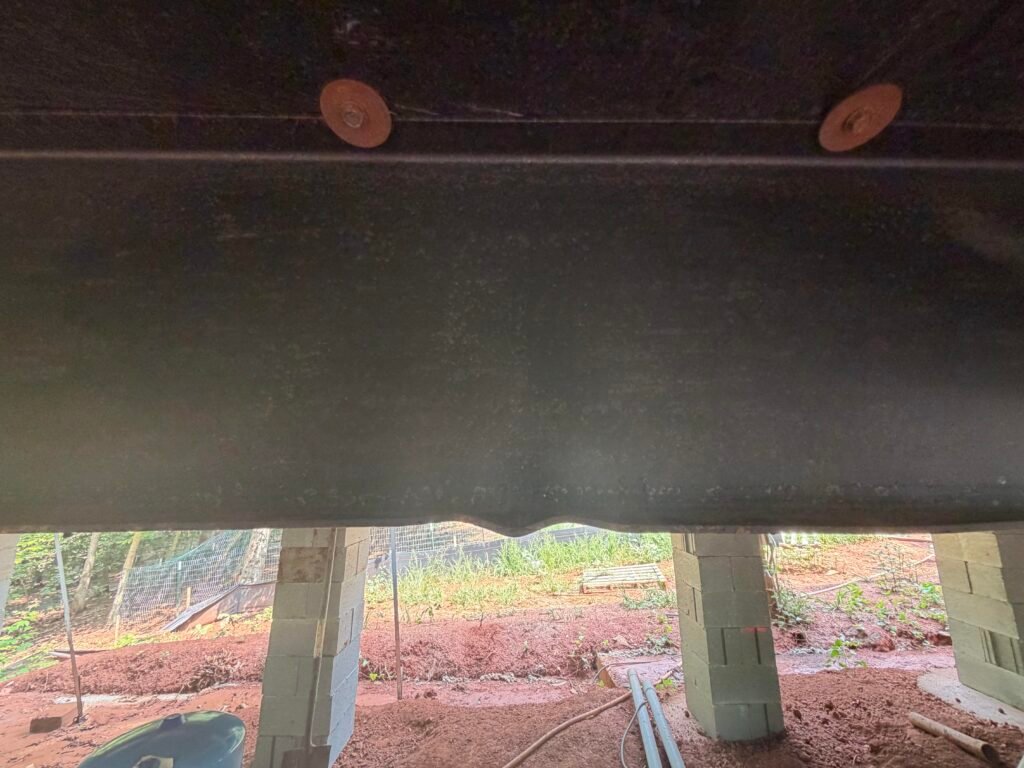 Damaged steel I-beam on a manufactured home chassis