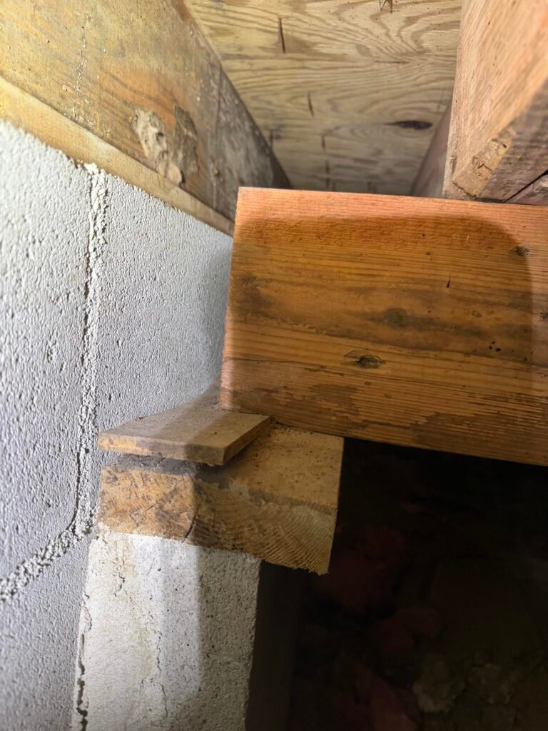 Girder not bearing on a cracked masonry pilaster, supported by a compressed wood shim