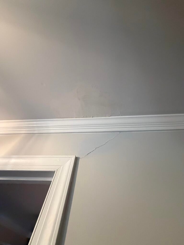 Settlement crack in drywall above an interior door