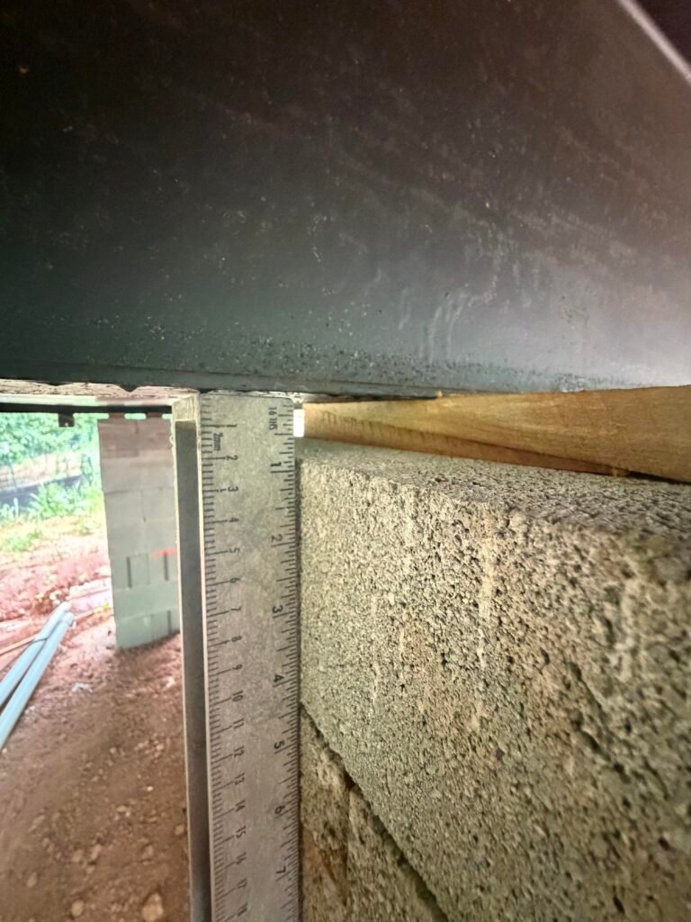 Wood shim placed beneath an engineered wood I-joist